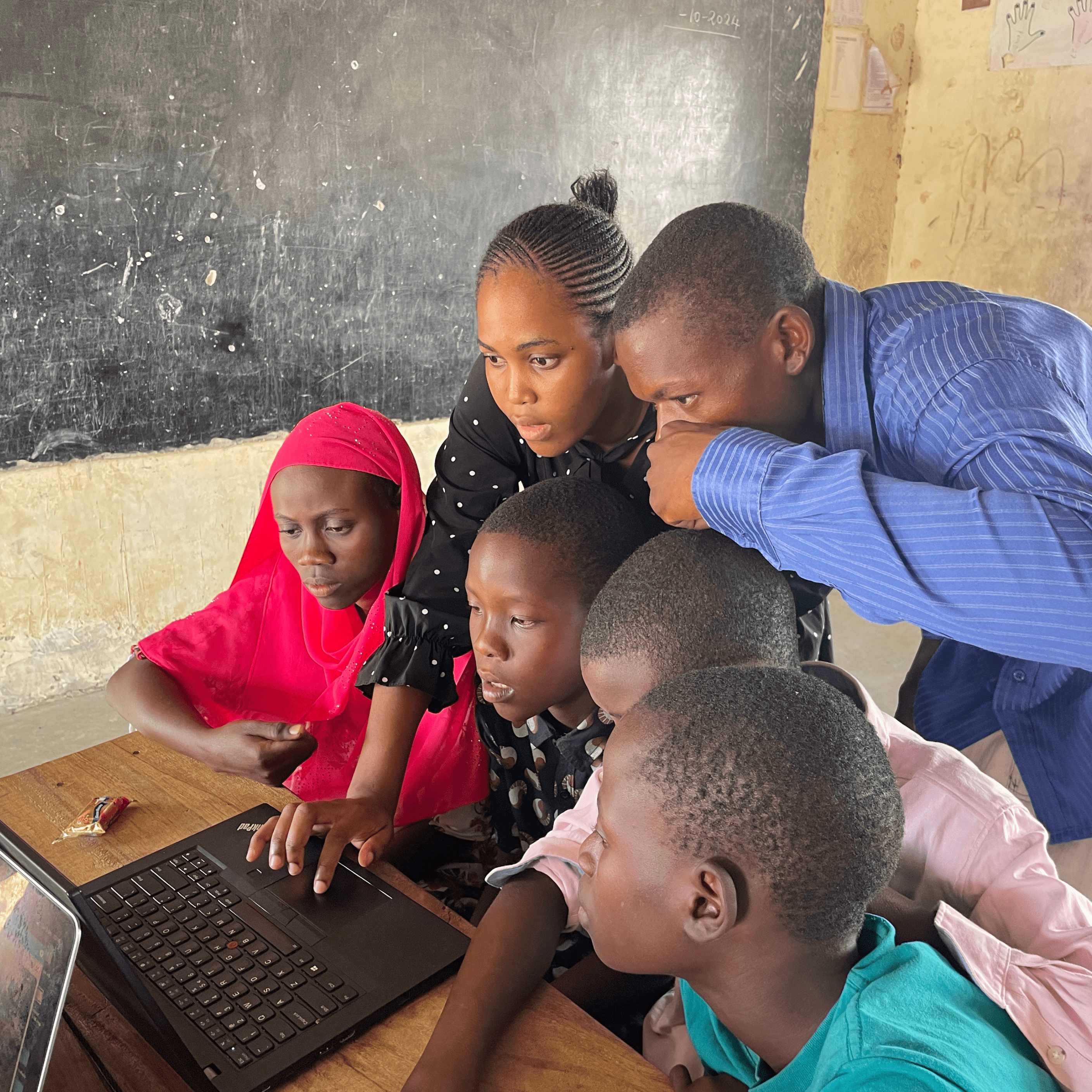 Trainer guiding students with laptops